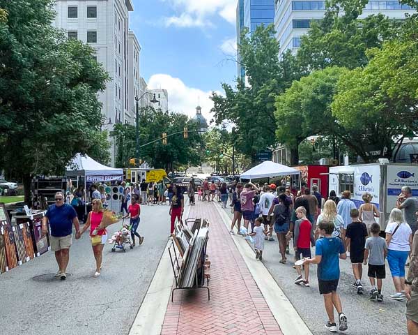 Soda City market shoppers with the State House in the background